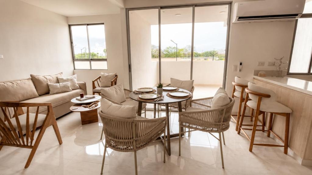 ein Wohnzimmer mit Tisch, Stühlen und Sofa in der Unterkunft Apartamento nuevo en Cartagena, Serena del Mar - INAWA in Cartagena de Indias