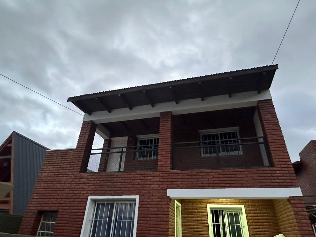 a red brick house with a black roof at aura in La Falda