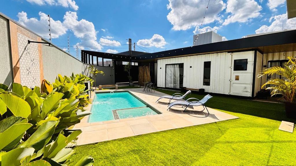 a backyard with a swimming pool and a house at Villa Container SBO Refúgio Urbano com piscina e jacuzzi in Santa Bárbara dʼOeste