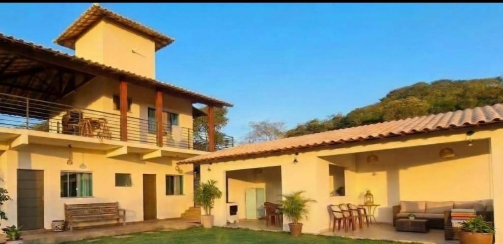 a house with a balcony and a patio at Pousada altavista acuruí in Itabirito