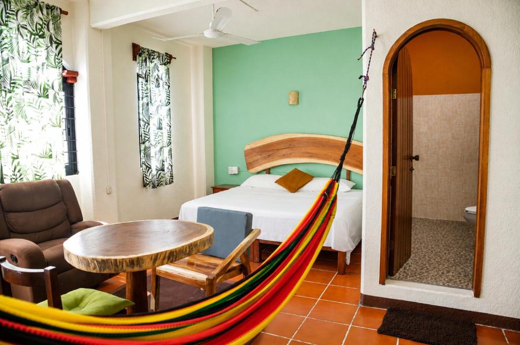 a room with a bed and a hammock in it at Casa San Jerónimo in Puerto Escondido