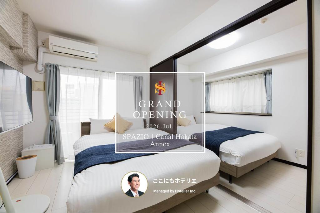 a room with two beds and a poster on the wall at SPAZIO 1 Canal Hakata Annex in Sumiyoshi