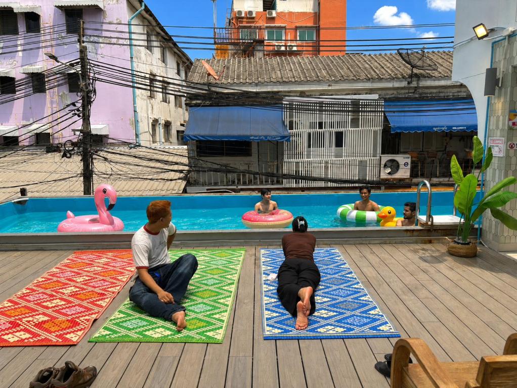 a group of people sitting on mats in a pool at Lazy Sunday Khaosan Hotel in Bangkok