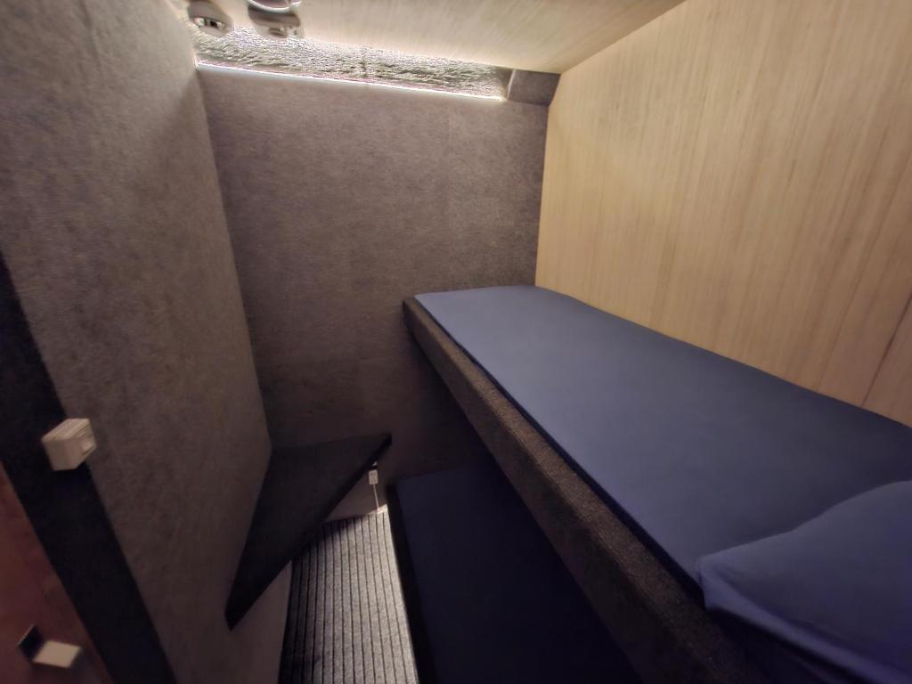 a small room with a blue bed in it at Capsule room with aircon in Manila