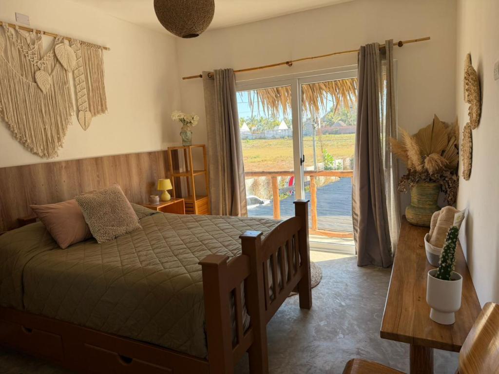 a bedroom with a bed and a sliding glass door at Green Tree El Paredon in El Paredón Buena Vista