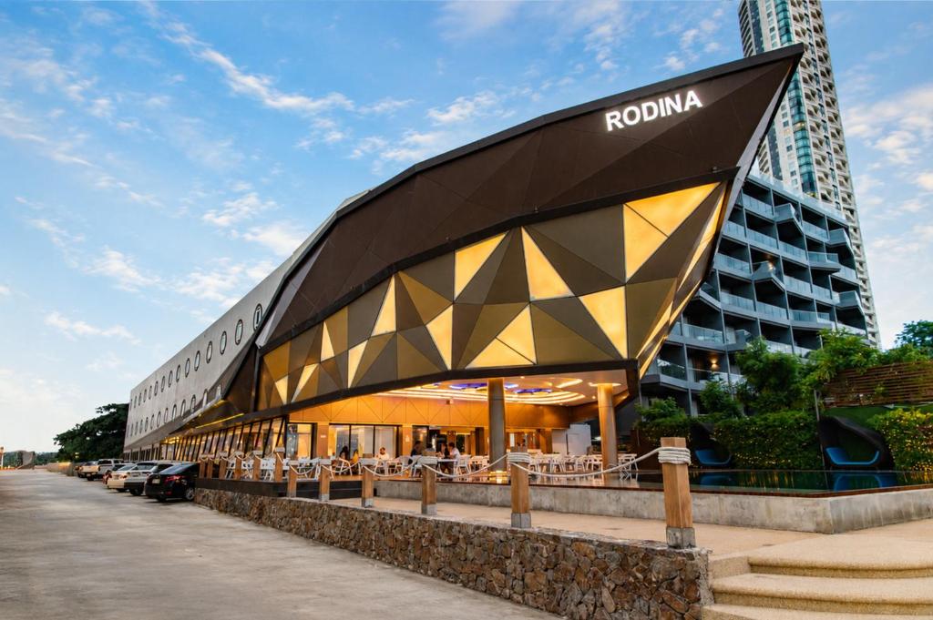 a building with a roof with a restaurant in front of a building at Rodina Beach Hotel in Jomtien Beach