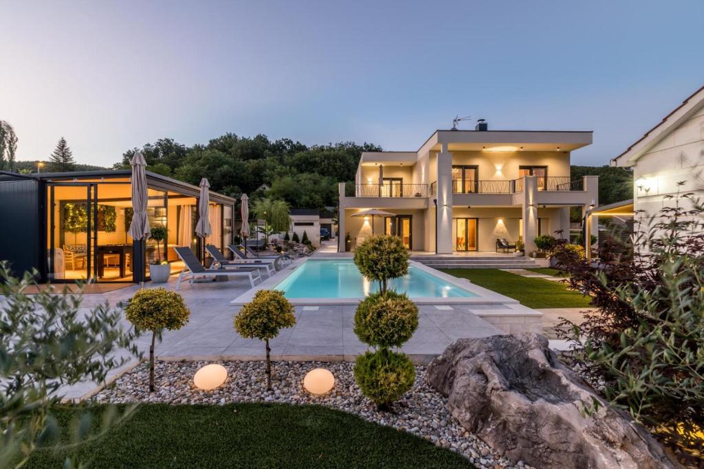 an exterior view of a house with a swimming pool at Countryside family villa with pool Zmina in Donji Muć