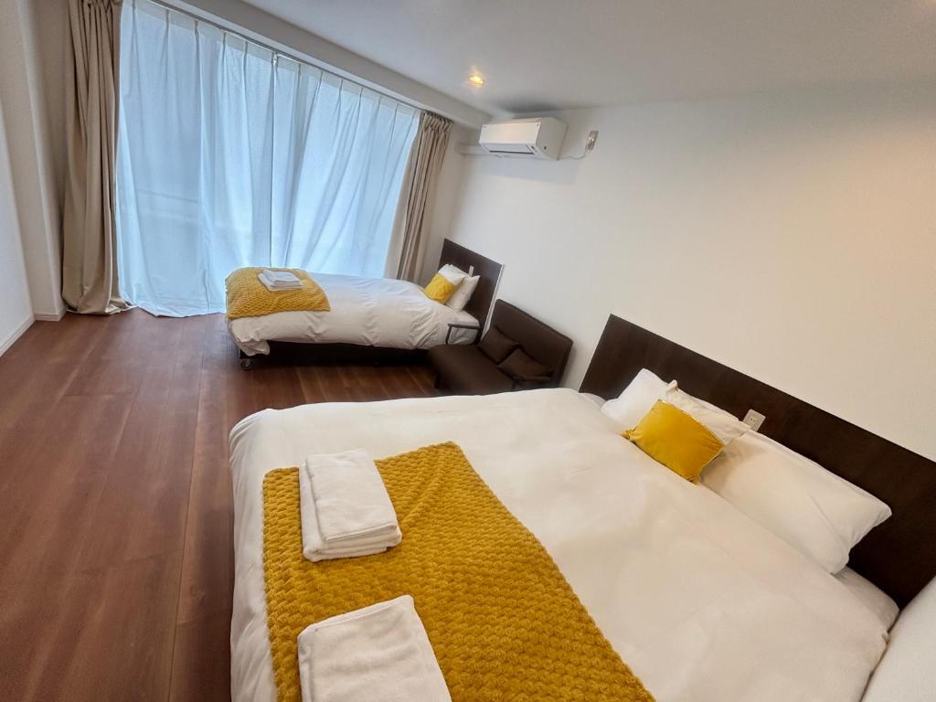 a hotel room with two beds and a window at New Happy Smile-Self Check In in Tokyo