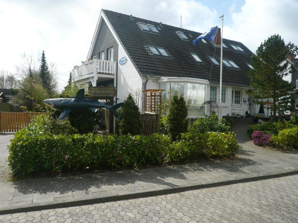 une maison avec une statue devant dans l'établissement "Haus am Deich", à Cuxhaven