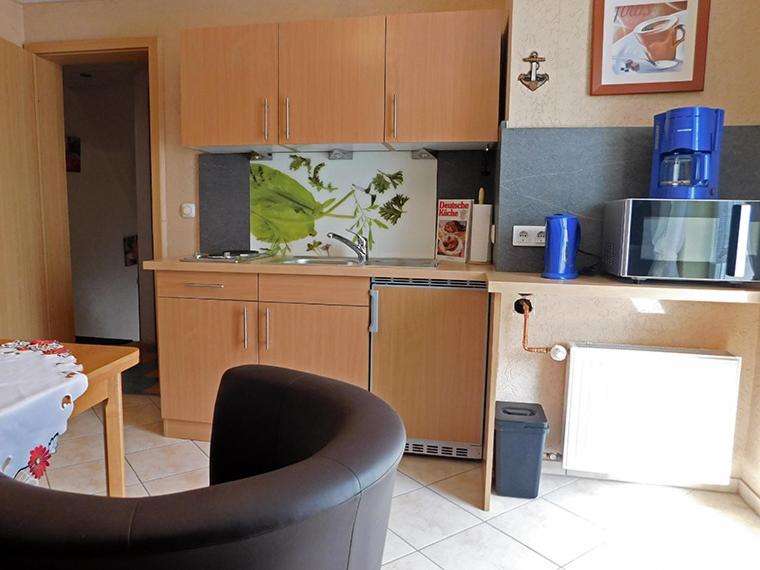 uma cozinha com um micro-ondas e uma mesa com uma cadeira em Haus Stricker em Sagard