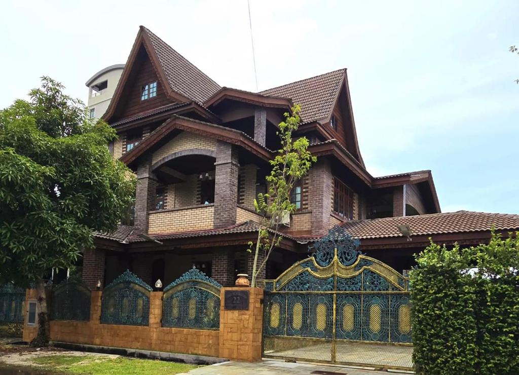 a large house with a wooden fence in front of it at CASA ALRAWDAH in Kuah