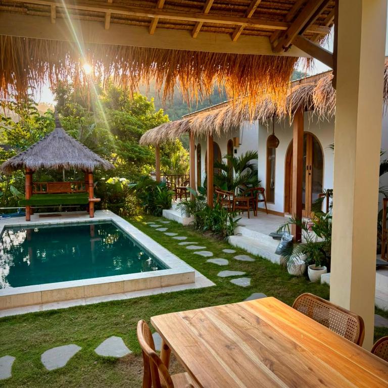 a patio with a table and a swimming pool at Bellis Garden in Kuta Lombok