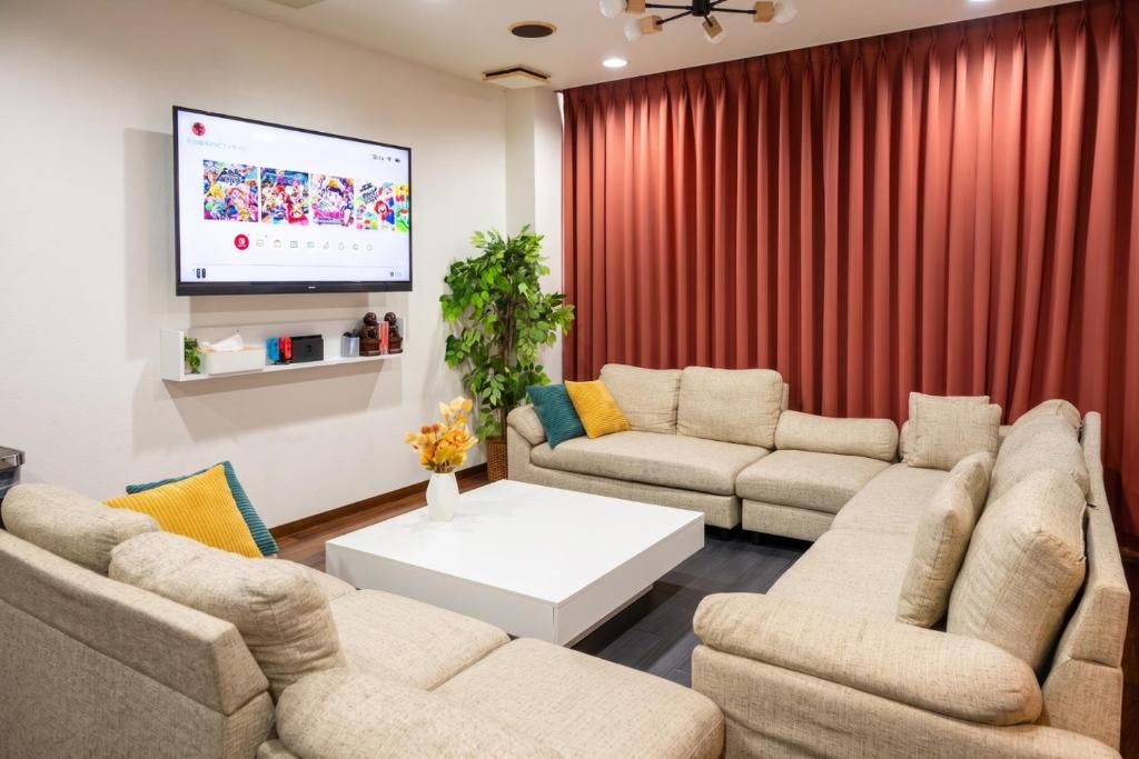 a living room with two couches and a flat screen tv at en stay001 in Osaka