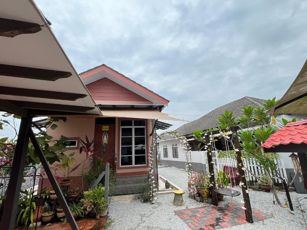 a house with a fence and plants in front of it at DGarden Homestay in Kuala Terengganu