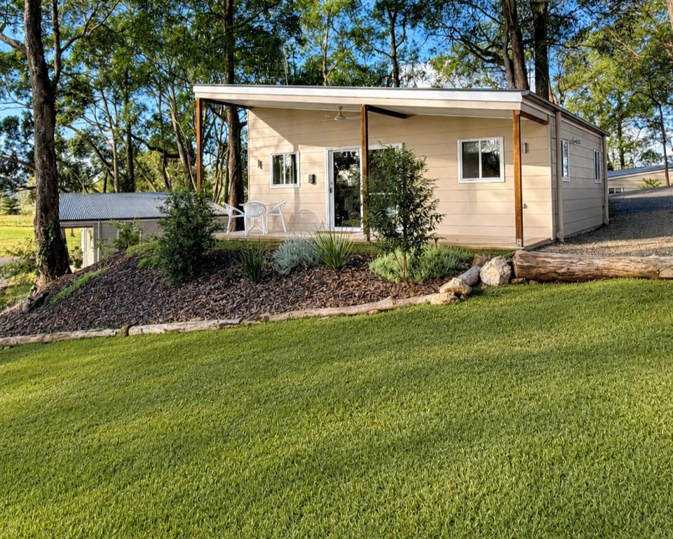 a small house with a lawn in front of it at Sunshine Coast Hinterland Retreat - Yandina Station in Yandina Creek