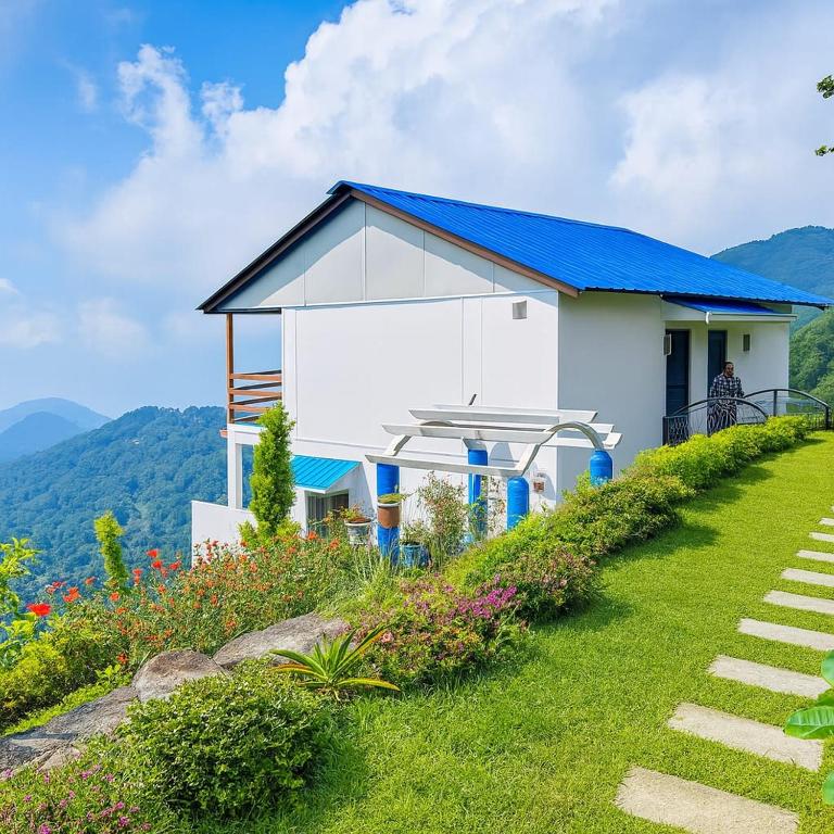 a white house with a blue roof on a hill at Salberry Hotel in Lansdowne