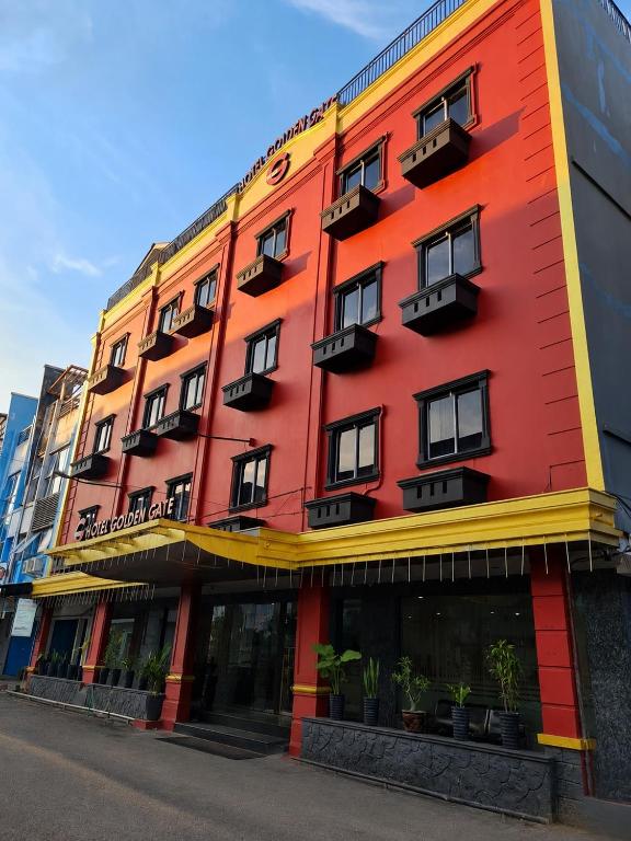 a red building with windows and plants on it at Golden Gate Hotel in Bagam