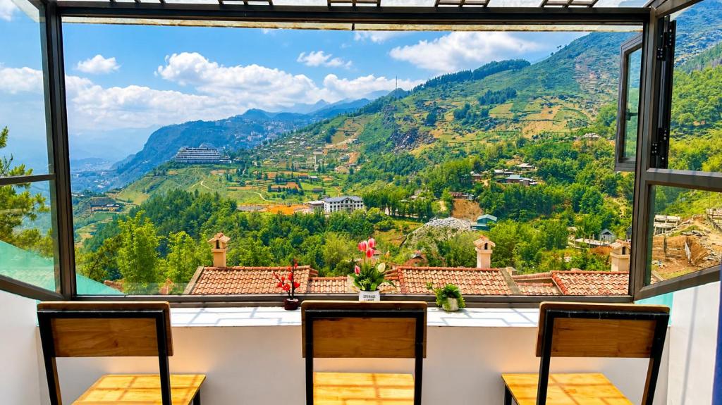 a room with a view of the mountains from a window at Sweet Apartment Sa Pa in Sapa