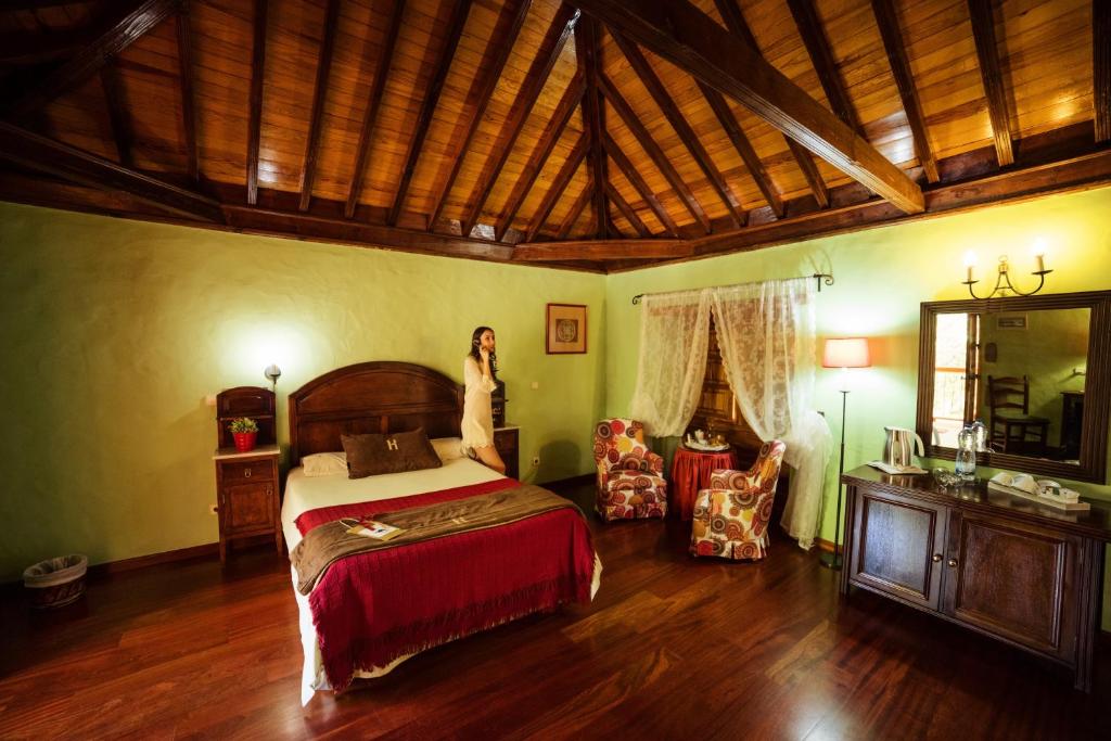 アグイメスにあるHotel Rural Casa de Los Camellosのベッド付き寝室に立つ女性