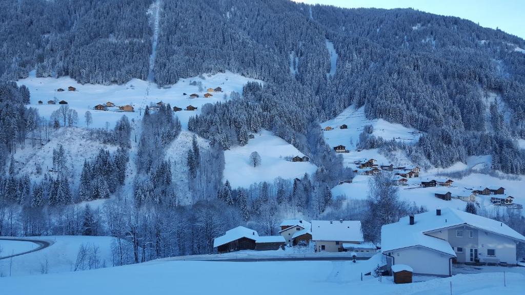 a small village covered in snow in front of a mountain at Haus Silke in Silbertal
