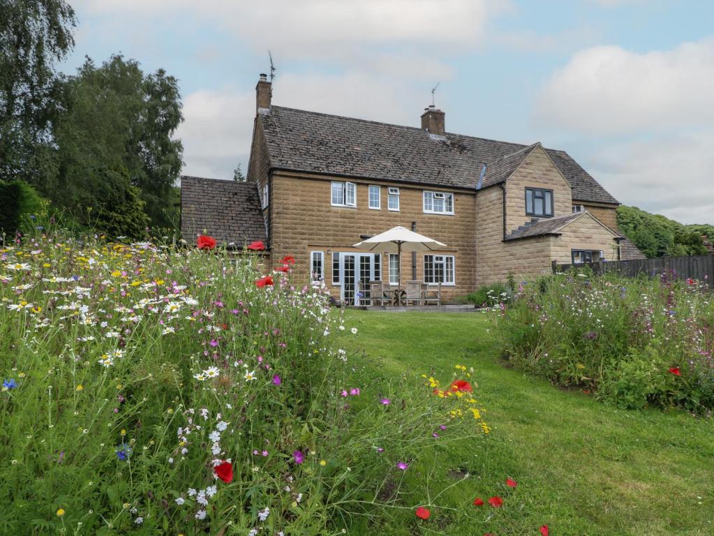 a house with a field of flowers in front of it at Ivet Lowe in Matlock