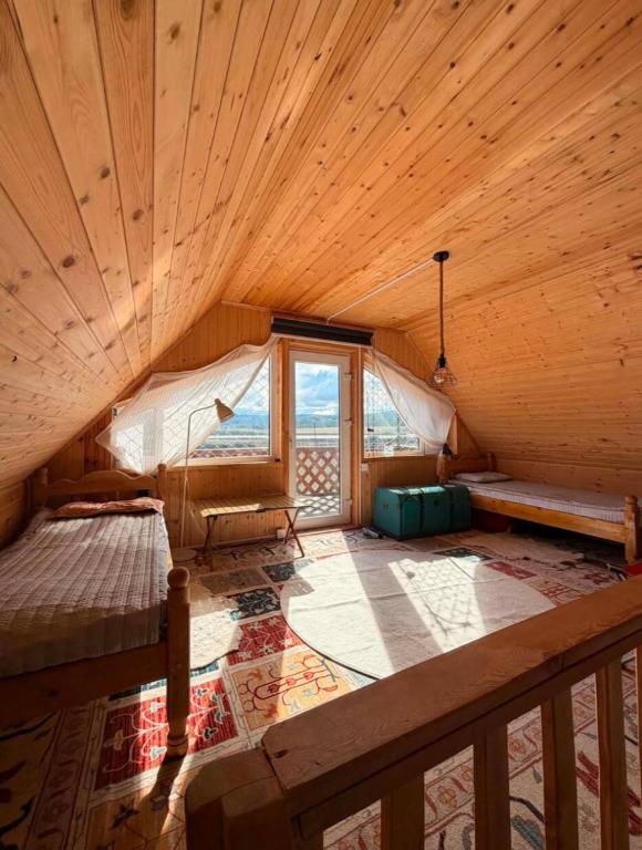 an attic room with a bed and a window at Mothers Modern Lakeside Cabin in Khyaktil