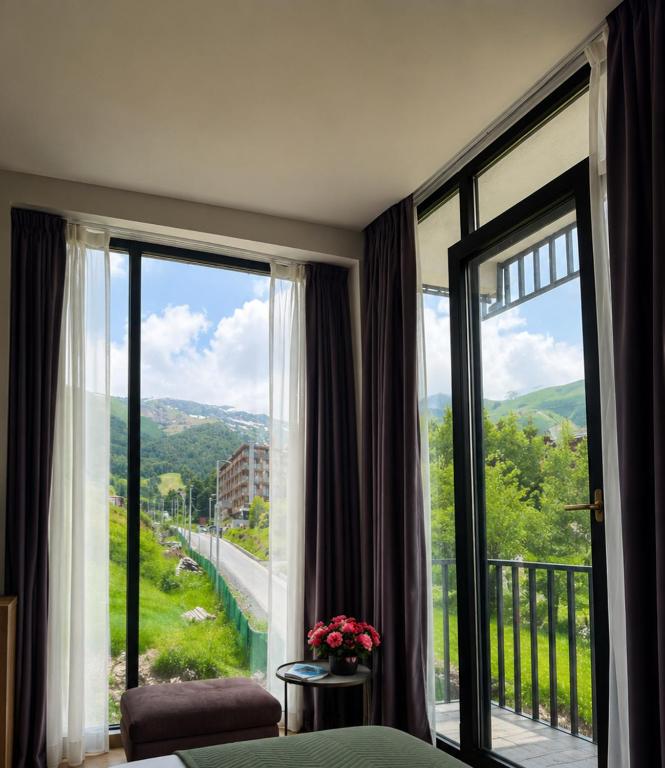 a bedroom with a large window with a view at Bakuriani - Didveli Gallery B212 in Bakuriani