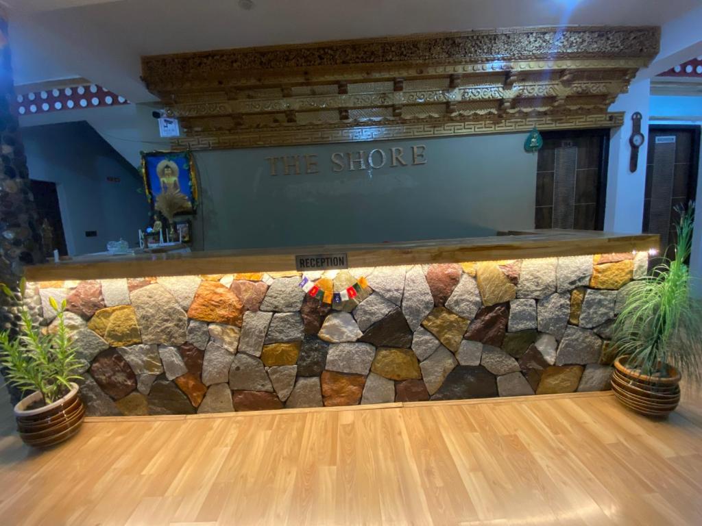 a stone wall in a bowling alley with two plants at The shore in Hundar