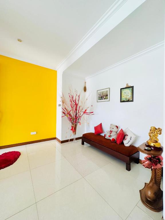 a living room with a couch and a yellow wall at Shek Residence in Colombo