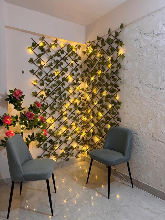 two chairs in front of a wall with wine bottles at Savera hommes in Ghaziabad