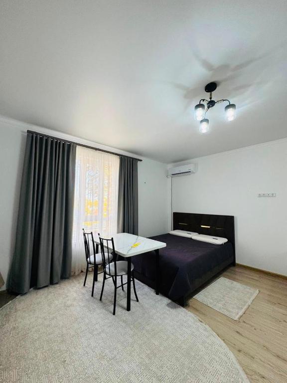 a bedroom with a bed and a table and chairs at Balor152 in Koshkolʼ