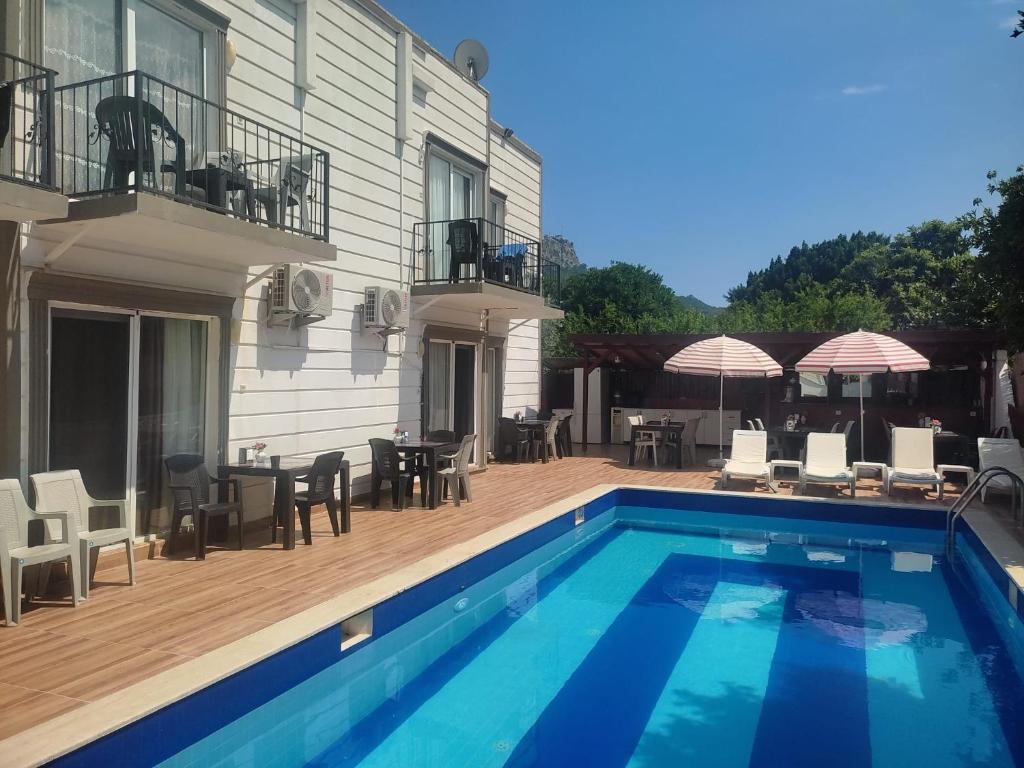 a house with a swimming pool and a patio at Garden Prizma Rooms&Aparts in Kemer