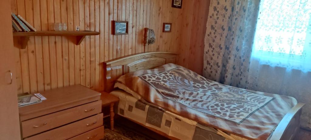 a small bedroom with a bed and a dresser at Буркут in Yaremche
