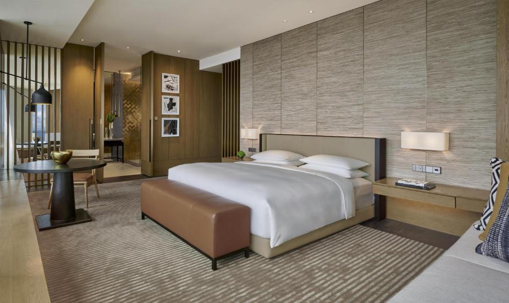 a bedroom with a large bed and a living room at Park Hyatt Kuala Lumpur in Kuala Lumpur
