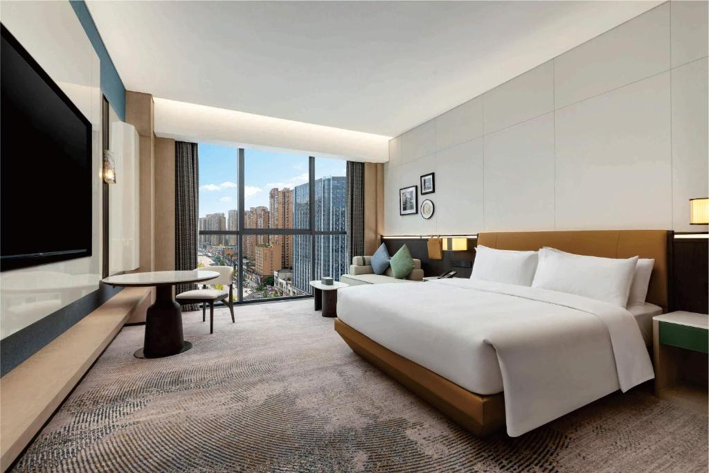 a hotel room with a large bed and a flat screen tv at Wyndham Leshan Downtown in Leshan