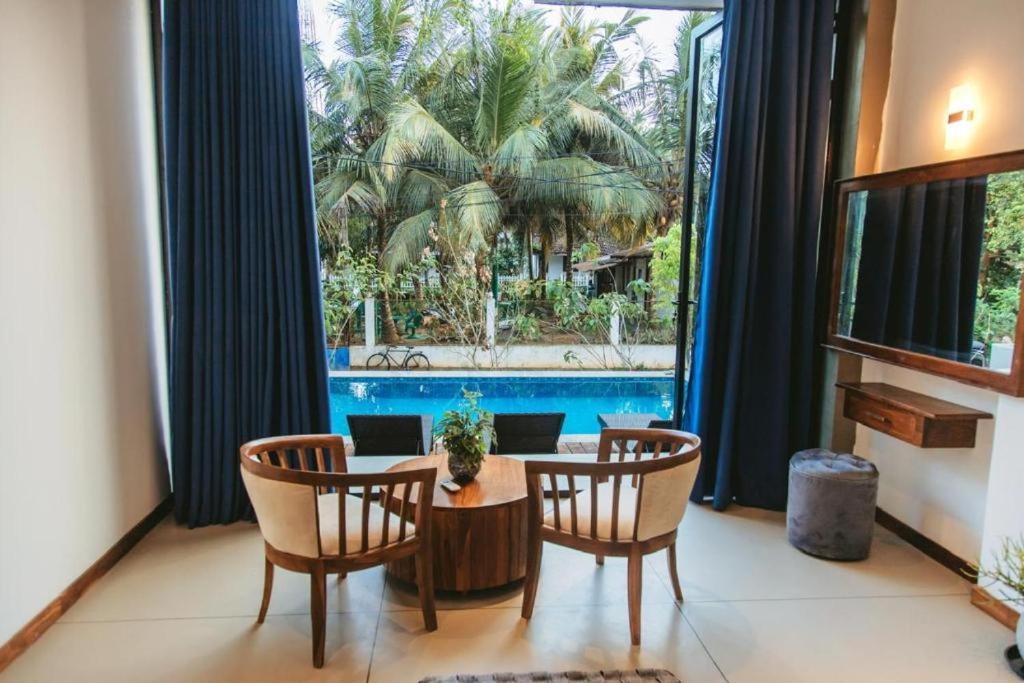 a room with a table and chairs and a large window at Luma Malee Resort in Dickwella