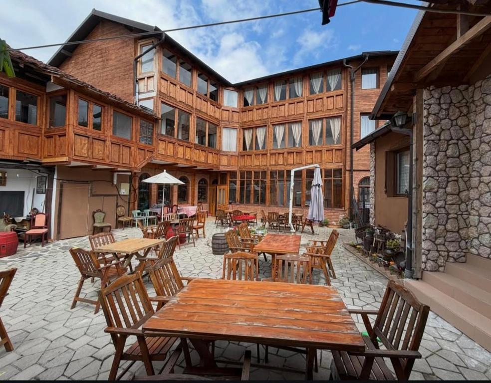 an outdoor patio with wooden tables and chairs at Etno kuca Petrovic in Štrpce