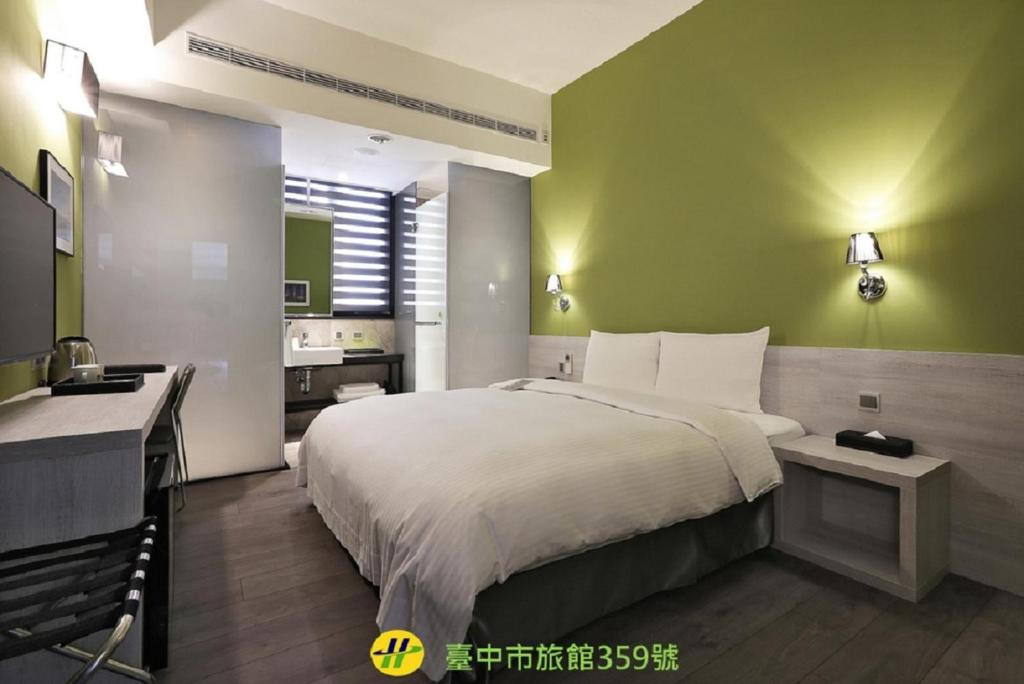 a bedroom with a large bed and a bathroom at Miller Inn in Taichung