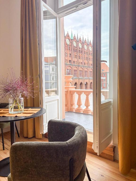 a room with a table and a chair and a window at Apartments am Alten Markt in Stralsund