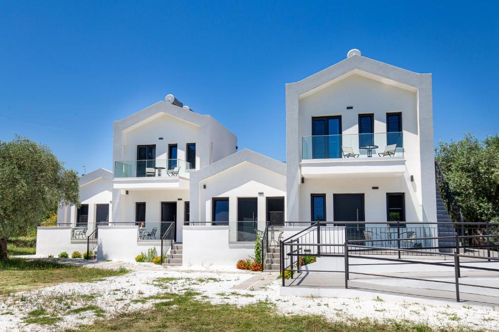 a white house with black doors and windows at O-live in Prinos