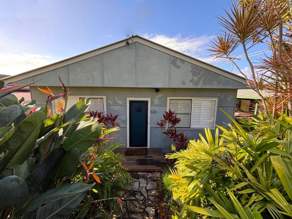 a white house with a blue door and some plants at Our Place in South West Rocks