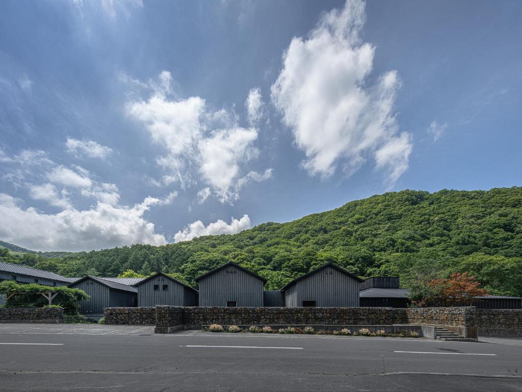 a row of houses in front of a mountain at OTARU RETREAT KURAMURE by Onko Chishin in Otaru