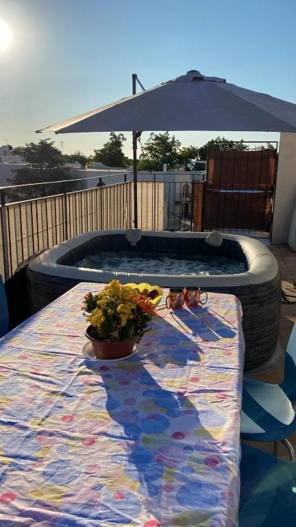 a table with flowers and an umbrella on a patio at Home Giove in Giardini Naxos