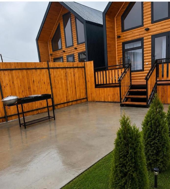a house with a deck and a bench in front of it at Esal house in Chon-Sary-Oy