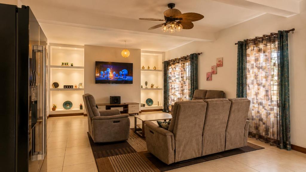 a living room with two chairs and a table at Villa de standing à Ivato in Antananarivo