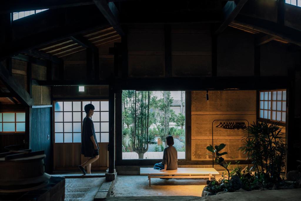 a woman sitting on a bench in a building at 暇家 kaya in Yosano