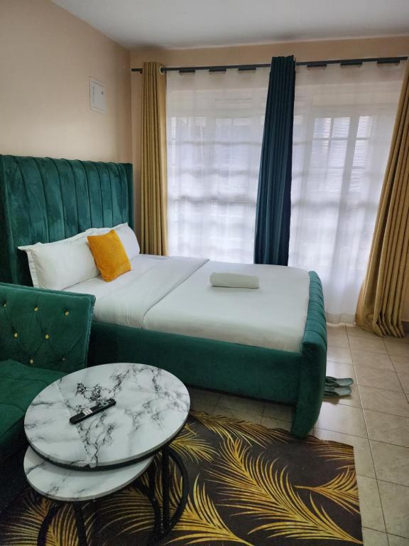 a bedroom with a bed and a couch and a table at PiemStays in Ruaka