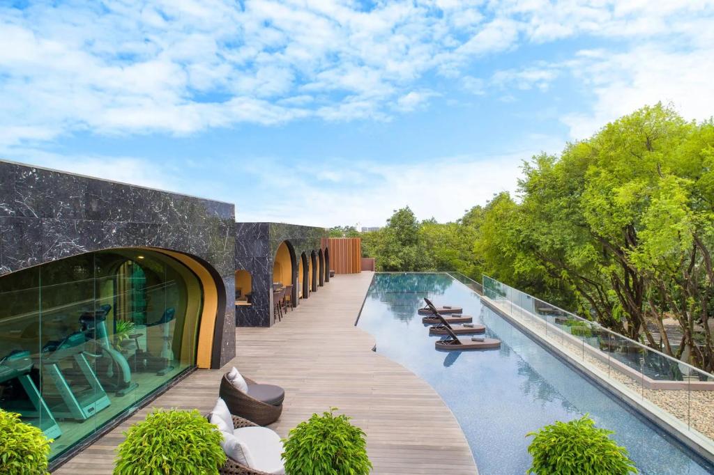 a swimming pool with lounge chairs and a building at Cross Chiang Mai Riverside in Chiang Mai