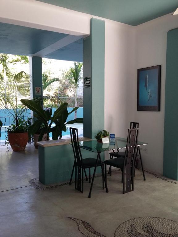 una sala da pranzo con tavolo e sedie di Delphinus Inn a Santa Cruz Huatulco
