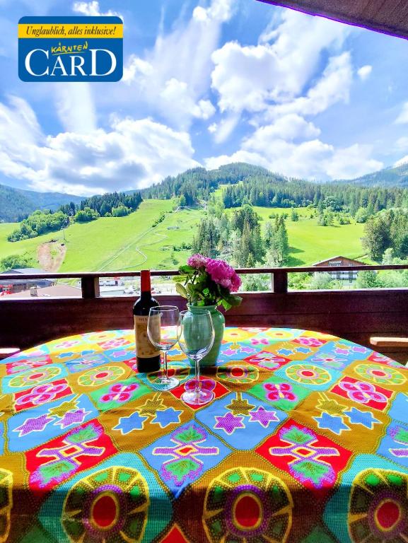 a table with two glasses and a bottle of wine at Appartements Römerhof Superior - Kärnten Card im Sommer inklusive in Bad Kleinkirchheim